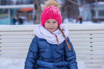 Adorable little girl outdoor in the park on winter day