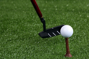 Golf ball and driver on green grass outdoor close up