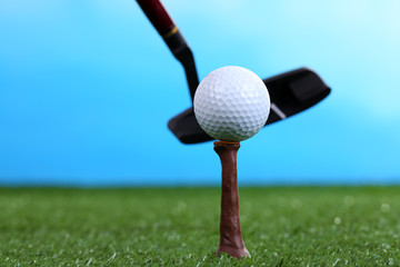 Golf ball and driver on green grass outdoor close up