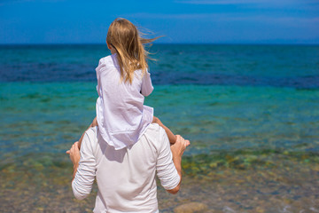 Adorable little girl and happy father during beach vacation