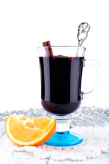 Glass of festive mulled wine on color wooden background