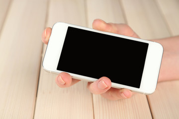 Hand using smart mobile phone on wooden table background