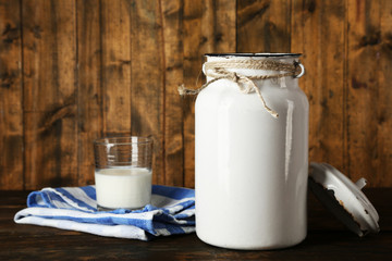 Open milk can on dishcloth on rustic wooden background