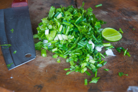 Chopped green onions on a cutting board and .knife