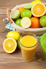 Fototapeta na wymiar Citrus fruits in basket and glass of juice. Oranges, limes and l