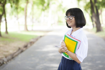 Schoolgirl standing holding a book.