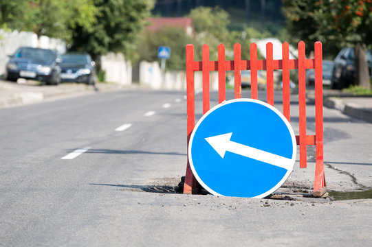 Road Sign And Barrier At City Street Due A Pothole