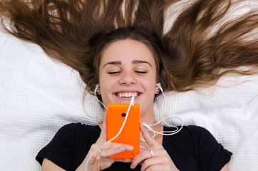 Teenager have fun with mobile laying on the bed
