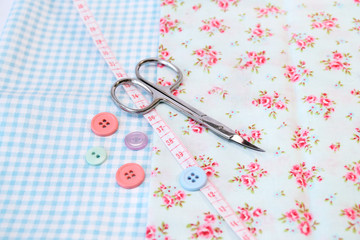 Sewing tools and vintage fabric background with scissors