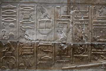Egyptian hieroglyphics on stone relief close up