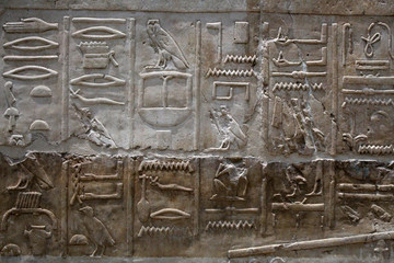 Egyptian hieroglyphics on stone relief close up