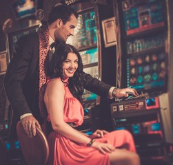 Beautiful couple near slot machine in a casino