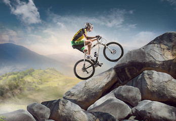 Sport background. Cyclist climbing on a rock.