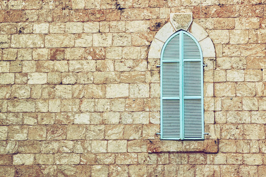 old house's wall from jerusalem stone and old blue iron shutters