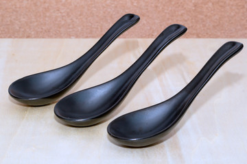 Three ceramic black spoons