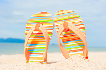 Holidays Background. Beach sandals on the sandy coast