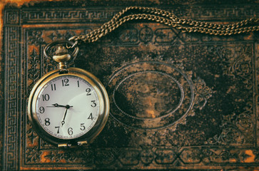 Fototapeta na wymiar macro image of old vintage pocket watch on antique book. top vie