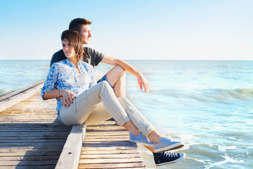 Young Couple Sitting on Wooden Pier