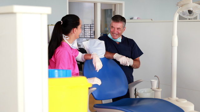 Smiling dentist team chatting with assitant
