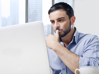 attractive businessman working on computer at office desk