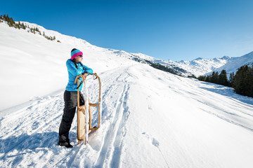 Fototapeta na wymiar Young woman with a sledge enjoying winter