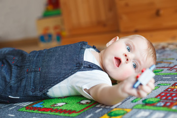 Lovely baby boy playing at home.