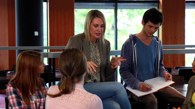 Students and tutor discussing in the library
