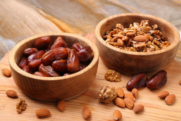 Fruits dates and nuts in wooden bowl  on  table