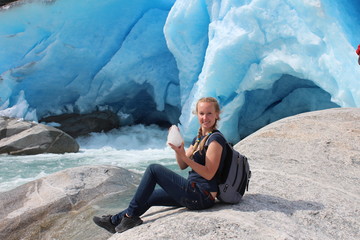 Young woman on the Nigardsbreen, sitting with piece of ice.