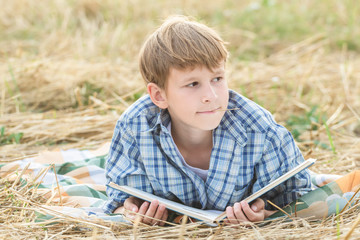 Teenage boy dreaming reading book