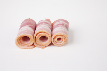Rolled raw bacon slices