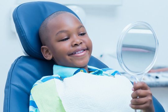 Boy Looking At Mirror In The Dentists Chair