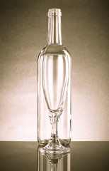 Empty bottle and an empty glass of clear glass. With Reflection