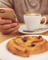 unrecognisable man drinking coffee and holding smart phone