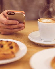 unrecognisable man drinking coffee and holding smart phone