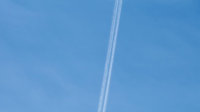Jet stream from plane flying on blue sky