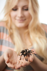 girl holding a large spider on her hands