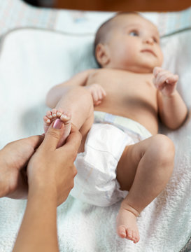 Mom checks reflex child on foot