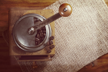 top view over old manual coffee grinder on wooden table