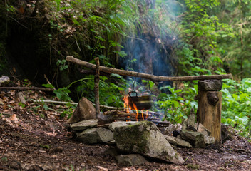 Camping kettle over burning campfire
