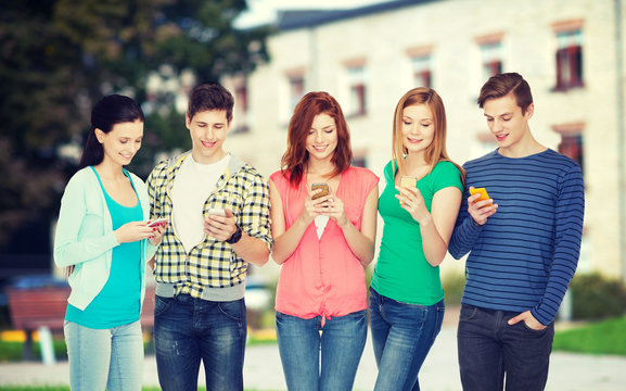 smiling students with smartphones