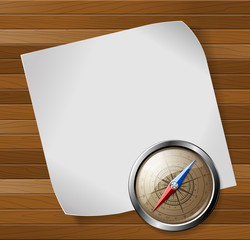 Steel compass and white paper sheet over wooden background.