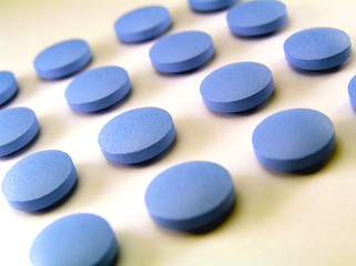 Obraz na płótnie Canvas Blue pills lined up in rows