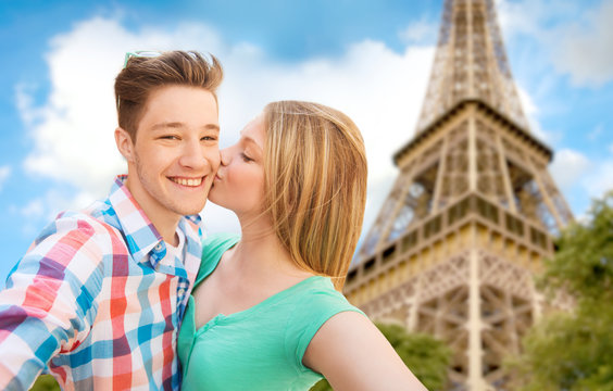 happy couple taking selfie over eiffel tower