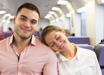 Obraz premium Young couple sitting in modern train
