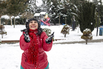 Fototapeta na wymiar Happy young Turkish woman plays with a snow outdoor