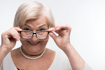 Curious granny looking through her glasses