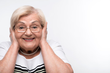 Elderly woman closes her mouth, ears and eyes with hands