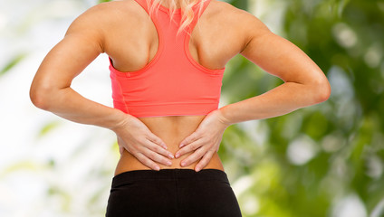 close up of sporty woman touching her back