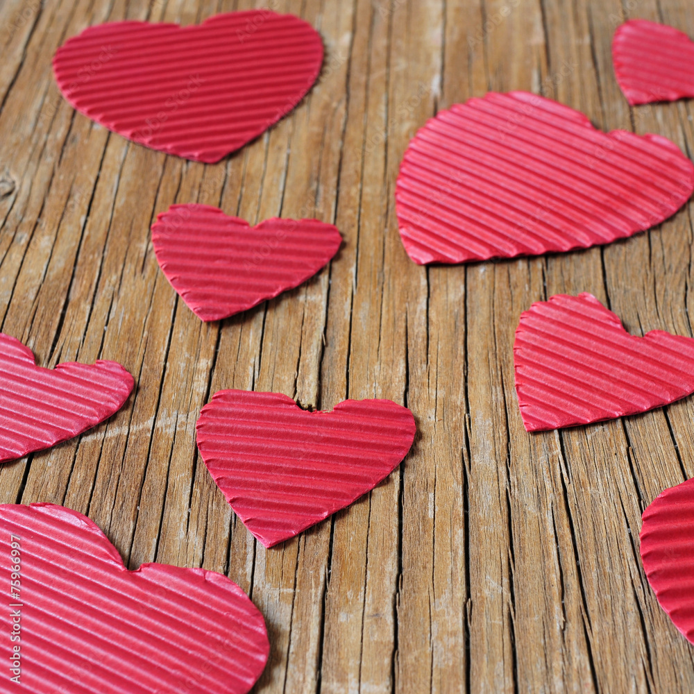 Poster red hearts on a rustic wooden surface